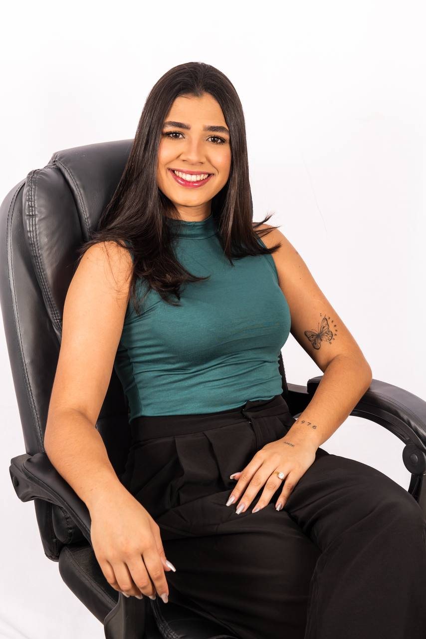 Nutricionista Mirella da Cal sorrindo, sentada em uma poltrona